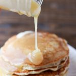 Pouring homemade syrup on a stack of pancakes.