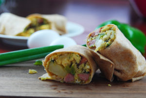 Front view of halved breakfast burritos.
