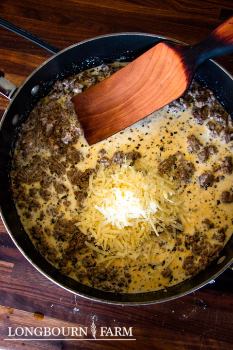 ground meat and white cheese in a skillet