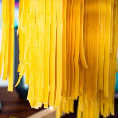 long pasta dough cut into noodles hang drying