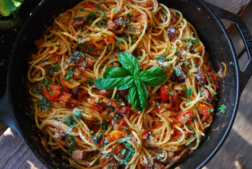 Cast iron pan with finished zucchini and sausage spaghetti.