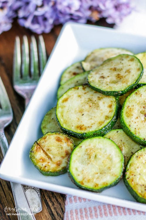Zucchini cooked on the stovetop on a white plate, close-up. 