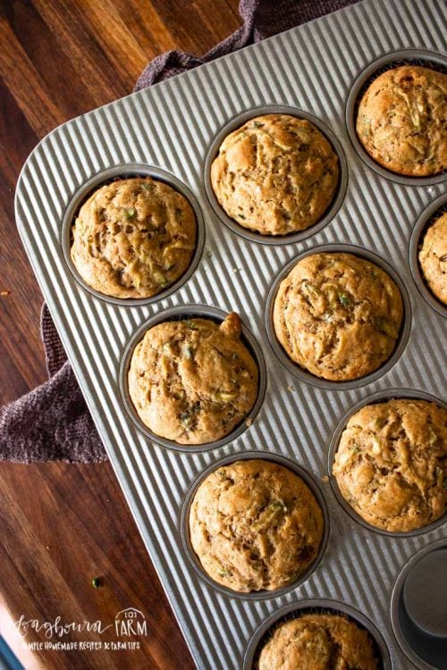 a muffin tray filled with baked zucchini muffins