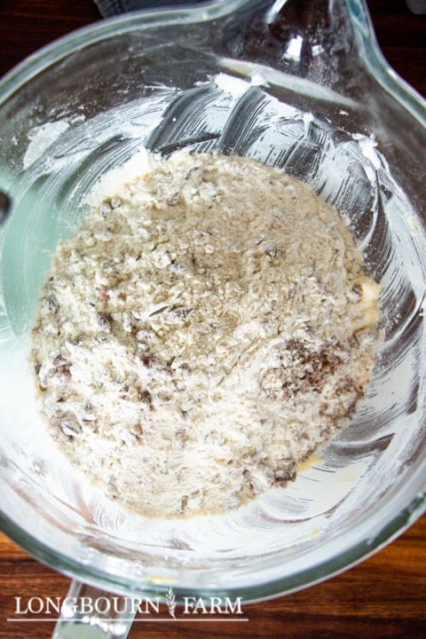 adding dry ingredients and nuts to the cookie dough butter mixture