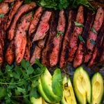 thinly sliced grilled flanksteak next to herbs and avocados