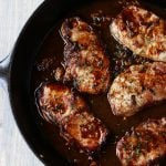 Pan seared pork chops in a cast iron skillet.