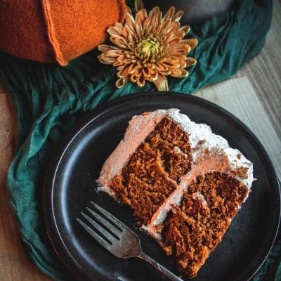 a slice of layered pumpkin cake on a plate with a fork