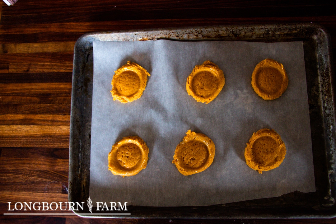 pressed pumpkin sugar cookie dough on parchment lined baking sheet
