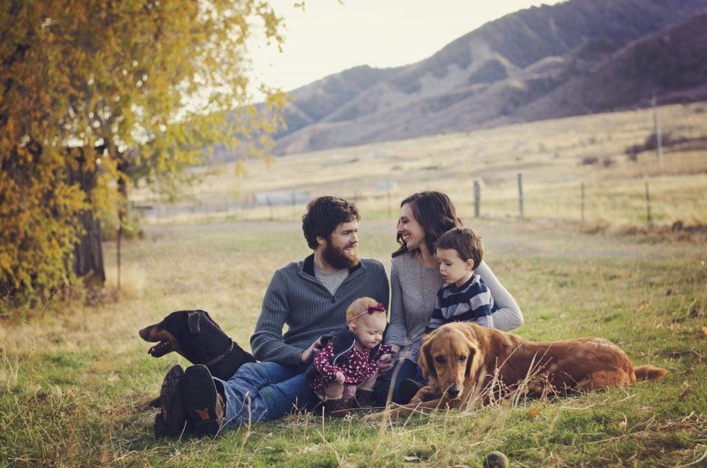 Alli, Andy, kids, and dogs sitting on their property.