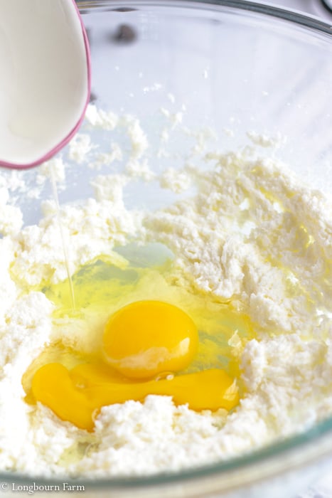 Two eggs in a bowl with creamed sugar and butter.