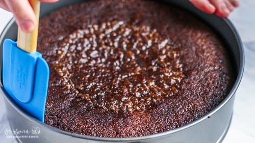 Loosening the sides of the baked basic chocolate cake from the edges of the springform pan.