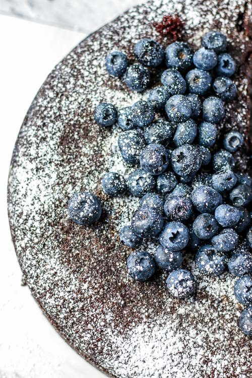 Top view of basic chocolate cake recipe topped with blueberries.