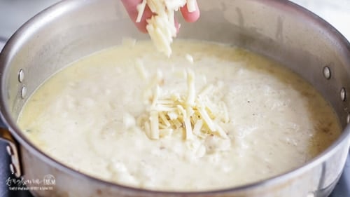 Adding parmesan cheese to the lemon cream sauce.