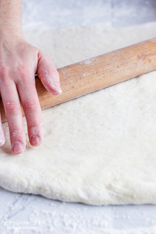 Rolling out orange roll dough.