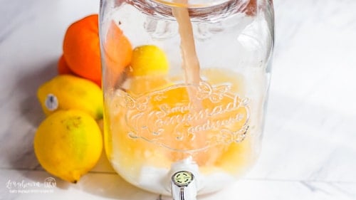 Pouring grapefruit juice into mixing vat for citrus lemonade.