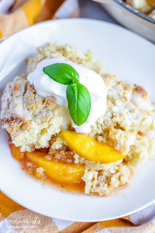 Easy peach cobbler is a family favorite! Flavorful and lightly spiced peaches topped with the softest crumb biscuit topping ever. So simple to bake up in a skillet, you'll be asked for the recipe again and again! #peach #peaches #cobbler #peachcobbler #fruitcobbler #peachdessert #dessert #baking #biscuit #shortcake #easydessert #simpledessert #quickdessert