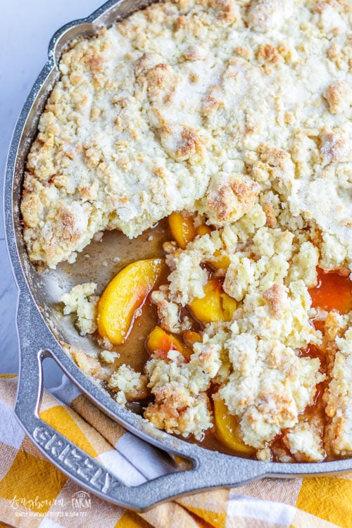 Partially served easy peach cobbler in a GRIZZLY Cast Iron skillet.