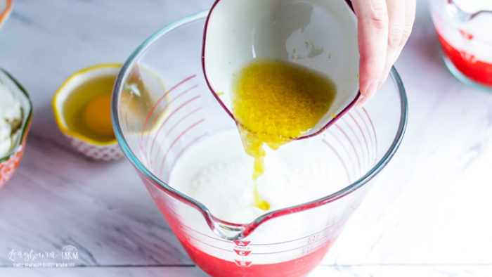 Adding lemon juice and lemon zest to wet ingredients for lemon ricotta pancakes.