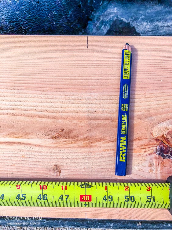 Measuring 4 feet on an 8 foot piece of wood for building raised planter beds. 