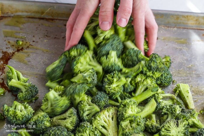 Tossing oven roasted broccoli.