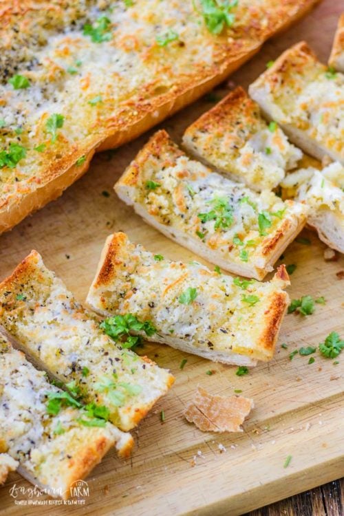 Close-up of cheesy garlic bread recipe cut up on a cutting board.
