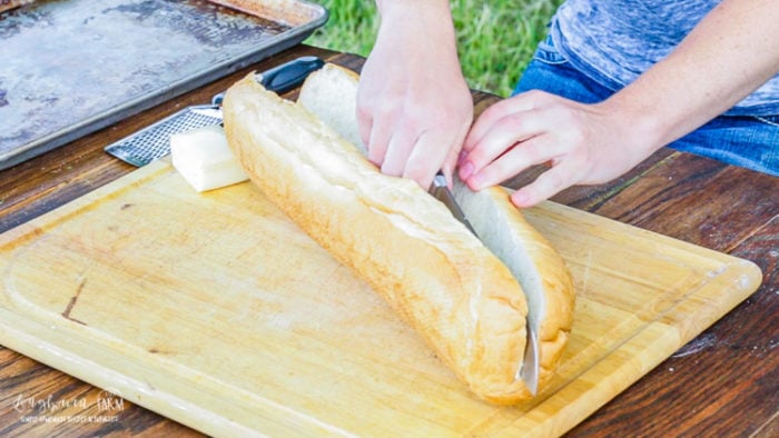 Slicing a loaf of french bread in half.