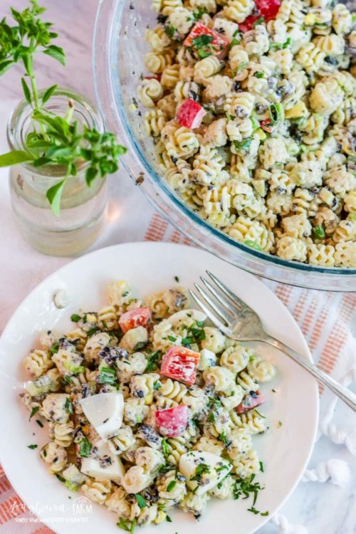 Plate of easy macaroni salad recipe next to a bowl of it.