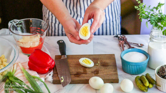 Perfectly hard-boiled egg being held up by a woman in an apron.