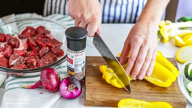 Chopping yellow pepper for steak kabobs.