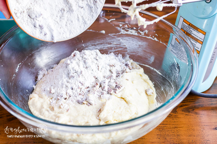 Adding the dry ingredients to the banana nut muffin batter.