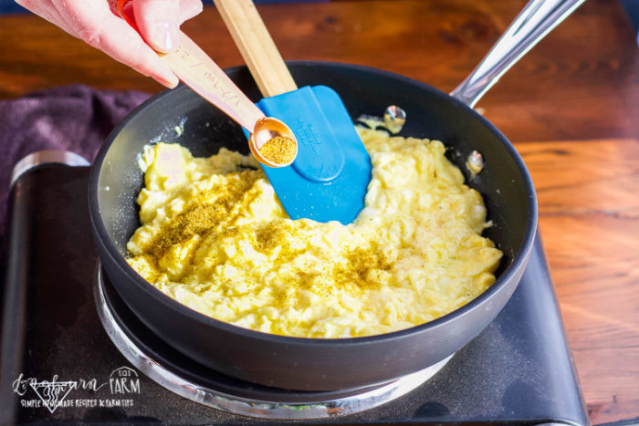Adding season salt to fluffy scrambled eggs. 