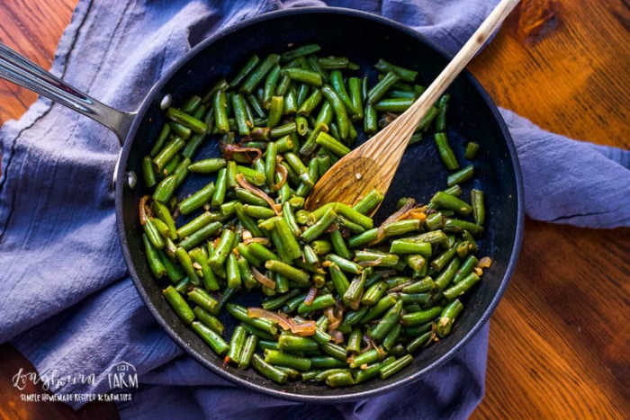 Frozen green beans in a saute pan.