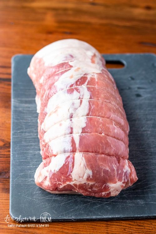 Raw pork tenderloin on a cutting board. 