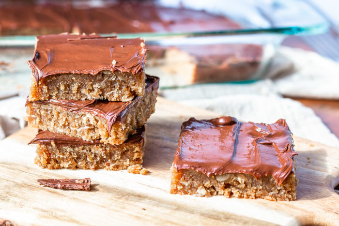 Chocolate peanut butter cookie bars stacked on a cutting board. 