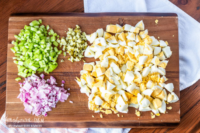 Easy egg salad recipe ingredients on a cutting board. 