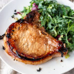 Asian pork chop on a plate with salad.