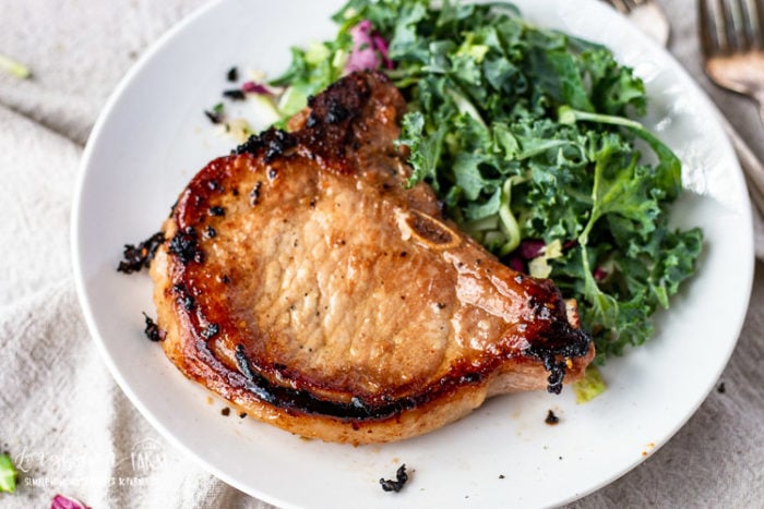 Asian pork chop on a plate with salad.