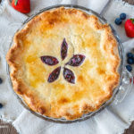 Baked mixed berry pie on a natural cloth.