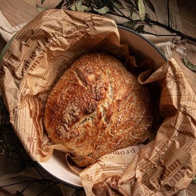 baked bread in a parchment lined dutch oven