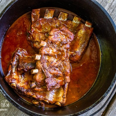 Dutch oven ribs are an easy but impressive dinner for home or when you're out camping! Get the step-by-step directions for both coal and oven dutch oven use and make these BBQ pork ribs today! #dutchoven #castironcooking #ribs #porkribs #bbqribs #bbqporkribs #bbqpork #castiron