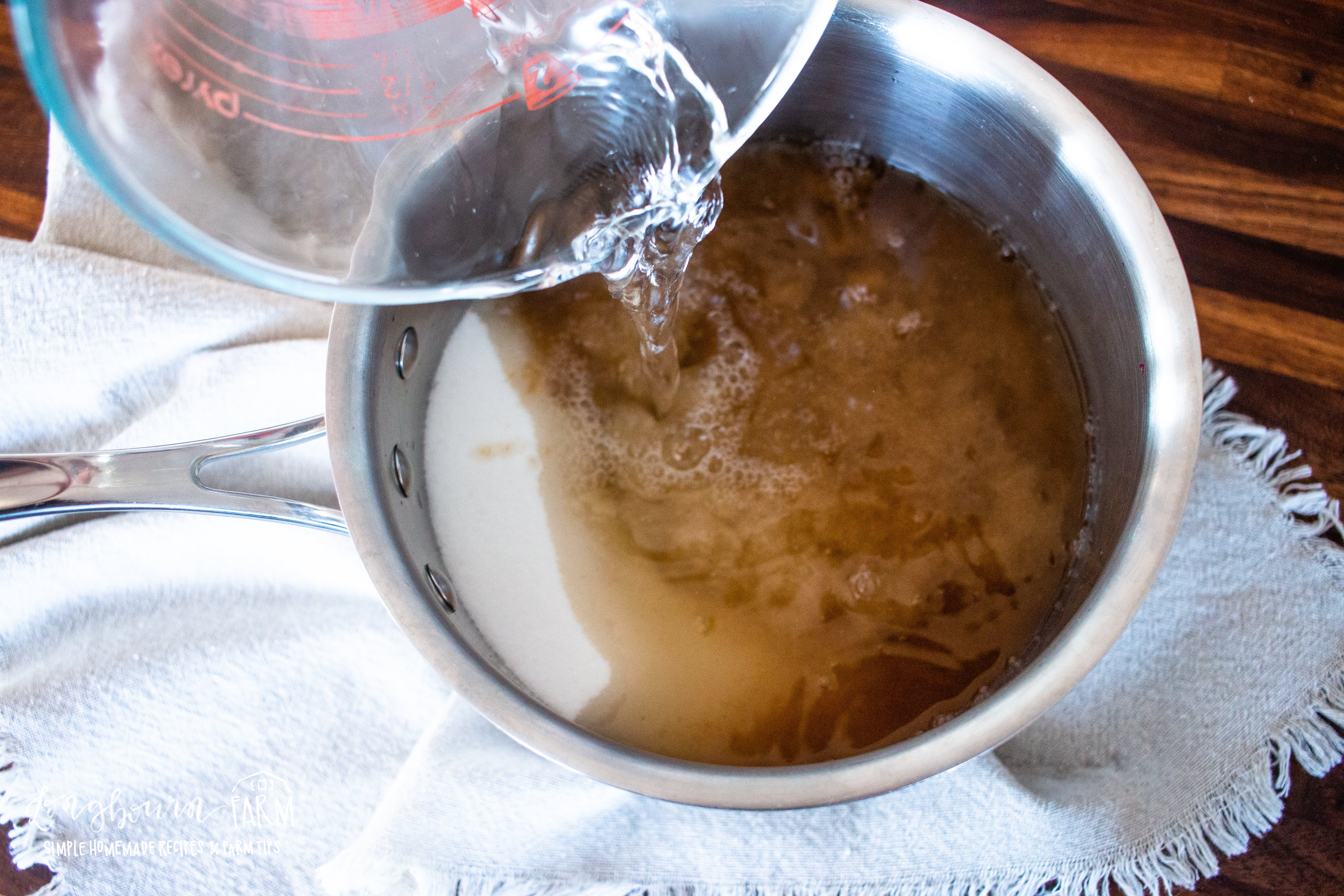 adding liquid to the pot of sugar