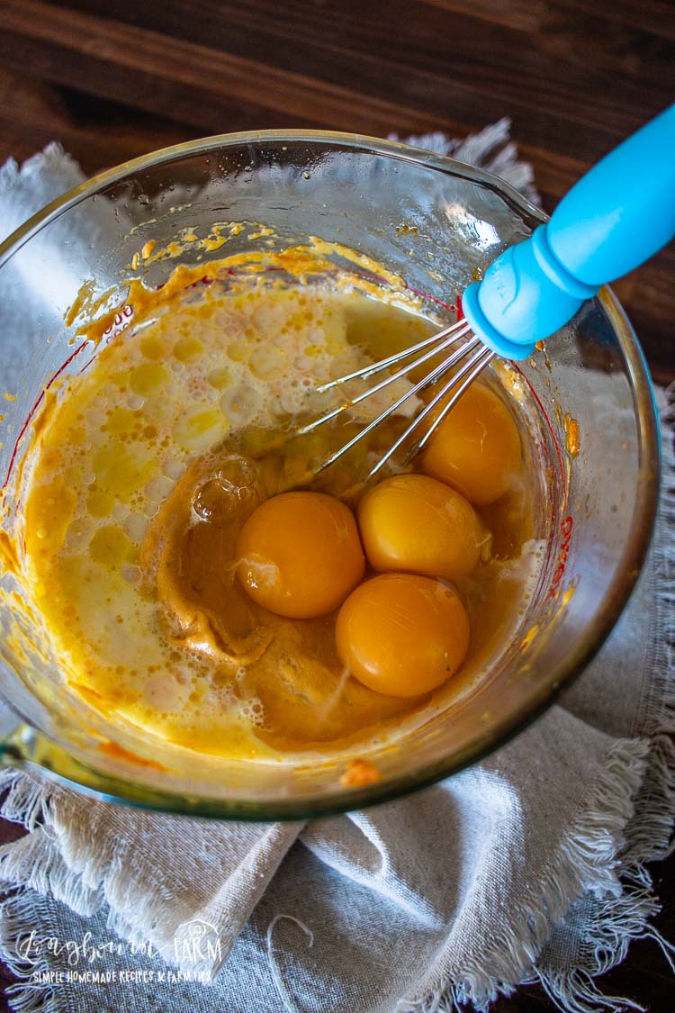 Whisking oil and eggs into the wet ingredients.