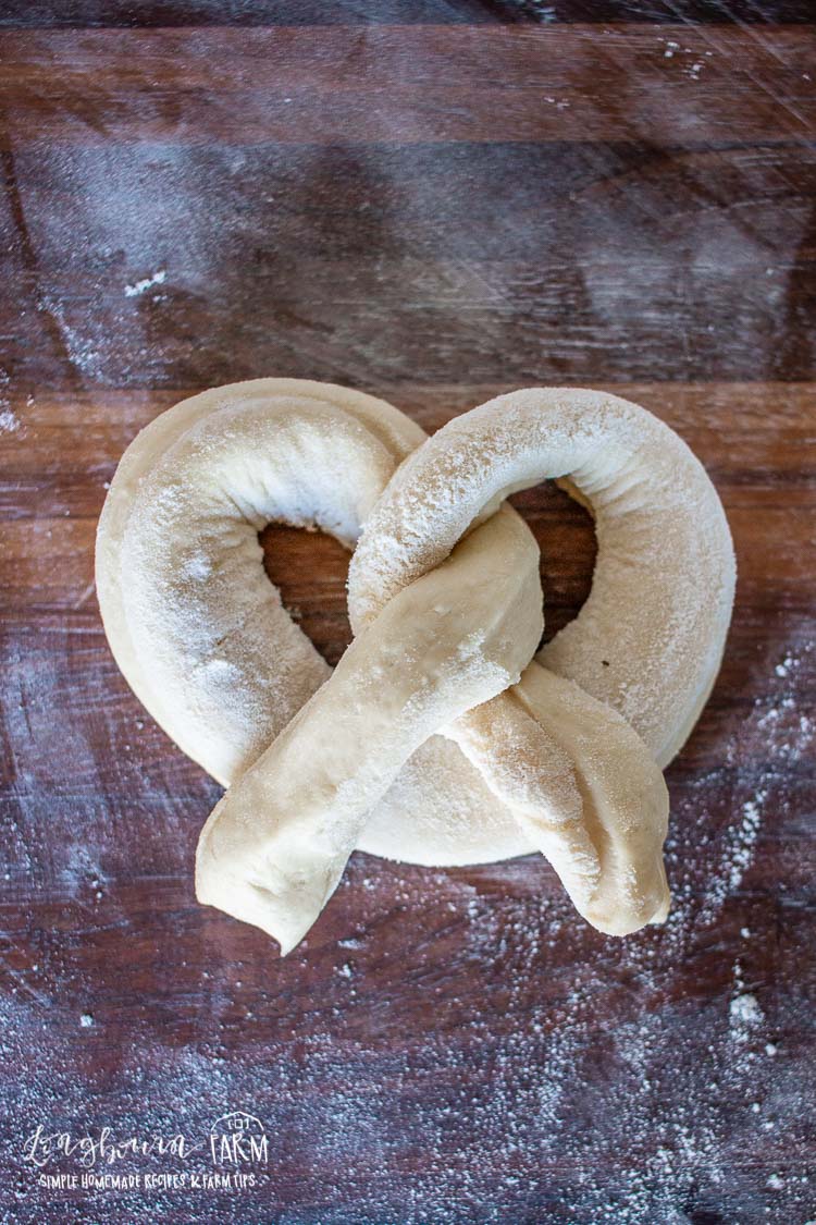 How to shape soft pretzels, step 3, twist the ends together and press them together.