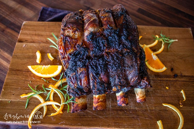 slow roasted prime rib fully cooked and on a cutting board garnished with sliced oranges