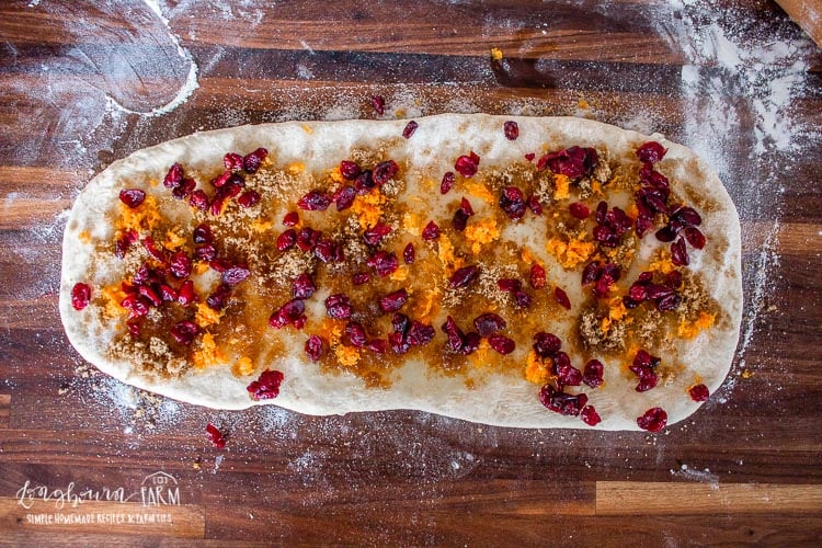 cranberry orange pull apart bread dough rolled and covered in orange zest and cranberry mix