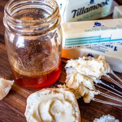 whipped honey butter on a whisk with a jar of honey and sticks of butter