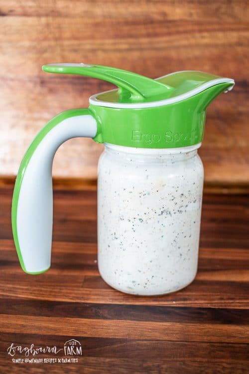 the mason jar full of dressing with an easy pour spout top piece