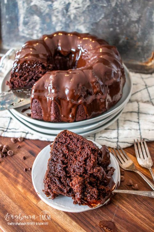 a slice of bundt cake on a plate in front of the chocolate bundt cake