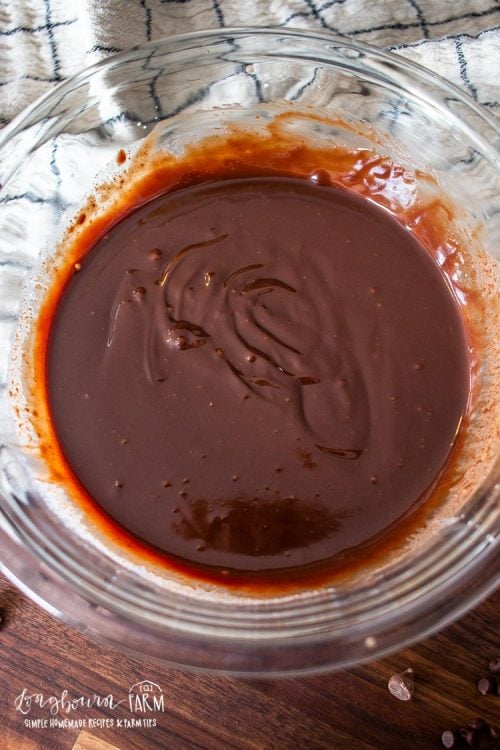 freshly mixed chocolate ganache in a clear mixing bowl