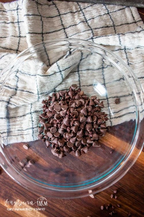 a clear mixing bowl with chocolate chips inside